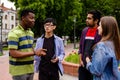 Outdoor communication between joyful multiracial college students Royalty Free Stock Photo