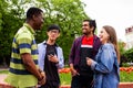 Outdoor communication between joyful multiracial college students Royalty Free Stock Photo
