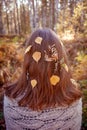 Outdoor conceptual photo of young beautiful lady. Brown hair with autumn fall leaves. Warm autumn, seasonal hair care Royalty Free Stock Photo