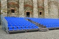 Outdoor concert venue with empty blue seats rows, mobile metal structure with plastic seats