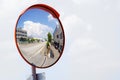 Outdoor convex safety mirror hanging on wall with reflection of an urban roadside view of cars parked along the street Royalty Free Stock Photo