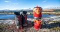 Outdoor cookery with propane gas boiler next to hiking boots with mountain scenery view.