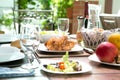 Outdoor dining meal complete with roast chicken, salad, bread rolls, wine and fruit in summer.