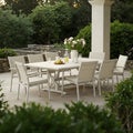 Outdoor dining set with a white extendable table and eight chairs on a patio Royalty Free Stock Photo