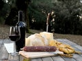 Outdoor eating with bread, cheese, sausage and red wine. Royalty Free Stock Photo