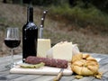 Outdoor eating with bread, cheese, sausage and red wine. Royalty Free Stock Photo