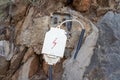 Outdoor electrical cable, leading to old junction box with lightning drown on the cover. Set in big stones and concrete