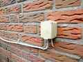 Outdoor electrical socket is mounted on the brick wall