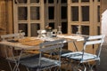 Outdoor empty coffee and restaurant terrace with white tables, vintage chairs and wine glasses in Europe. Cafe terrace