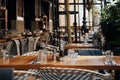 Outdoor empty coffee and restaurant terrace with wooden tables, vintage chairs and warm plaids. Green cafe terrace on Royalty Free Stock Photo