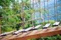 Outdoor exercise adventure activities, pioneering scout boardwalk wooden ladder bridge amidst green natural forest in the mountain