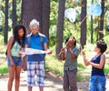 An outdoor experience. Multi-ethnic kids exploring a map while standing outside in a forest.