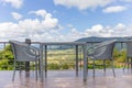 Outdoor exterior table and chair outside coffee cafe with beautiful mountain viewpoint and white clouds and blue sky background Royalty Free Stock Photo