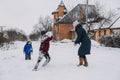 Outdoor family activities for happy winter holidays. Happy mother and two sons playing snowballs on snowy street in Royalty Free Stock Photo