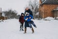 Outdoor family activities for happy winter holidays. Happy mother and two sons playing snowballs on snowy street in Royalty Free Stock Photo