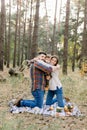 Outdoor family portrait of cheerful father, mother and little kid boy, having fun together, while sitting on the blanket Royalty Free Stock Photo