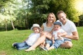 Outdoor family portrait of happy family of four in a green summer home garden Royalty Free Stock Photo