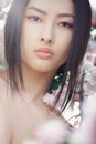 Portrait of a beautiful fantasy asian girl outdoors against natural spring flower background. Royalty Free Stock Photo