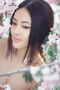 Portrait of a beautiful fantasy asian girl outdoors against natural spring flower background. Royalty Free Stock Photo