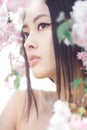 Portrait of a beautiful fantasy asian girl outdoors against natural spring flower background. Royalty Free Stock Photo