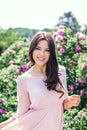 Outdoor fashion photo of beautiful young happy smiling woman surrounded by flowers. Spring blossom Royalty Free Stock Photo