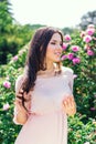Outdoor fashion photo of beautiful young happy smiling woman surrounded by flowers. Spring blossom Royalty Free Stock Photo