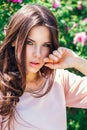 Outdoor fashion photo of beautiful young happy smiling woman surrounded by flowers. Spring blossom Royalty Free Stock Photo