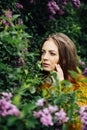 Outdoor fashion photo of beautiful young woman surrounded by flowers. Spring blossom Royalty Free Stock Photo