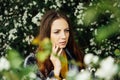 Outdoor fashion photo of beautiful young woman surrounded by flowers. Spring blossom Royalty Free Stock Photo