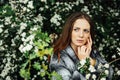 Outdoor fashion photo of beautiful young woman surrounded by flowers. Spring blossom Royalty Free Stock Photo