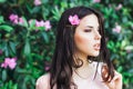 Outdoor fashion photo of beautiful young woman surrounded by flowers. Spring blossom Royalty Free Stock Photo