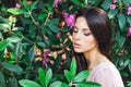 Outdoor fashion photo of beautiful young woman surrounded by flowers. Spring blossom Royalty Free Stock Photo