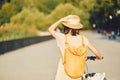 Outdoor portrait of attractive young brunette in a hat on a bicycle. Royalty Free Stock Photo