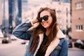 Outdoor fashion portrait of stylish young woman having fun, emotional face , laughing, looking at camera. Urban city street style. Royalty Free Stock Photo