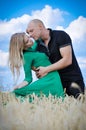 Outdoor fashion sensual portrait of young beautiful couple in love posing outdoor in the wheat field