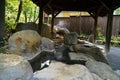 Outdoor feet hot spa with rock pool and wooden pillars roof, Kurokawa onsen Royalty Free Stock Photo