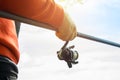 Outdoor fishing. Male hand holding a fishing rod outdoors close-up. Fisherman catches fish Royalty Free Stock Photo