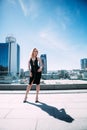 Outdoor full body portrait of a young beautiful fashionable woman posing on the street. Model looking at camera. Lady wearing styl Royalty Free Stock Photo