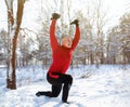 Outdoor functional fitness workout. Mature man using bodyweight resistance straps, doing lunges at snowy winter park