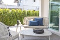 Outdoor furniture rattan chairs, table and blue pillow by the home patio. Royalty Free Stock Photo