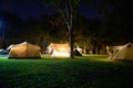 Outdoor Glamping tent at night on grass courtyard and warm night light under dark blue sky twilight time, Group of family vacation Royalty Free Stock Photo