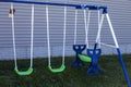 An outdoor green and blue swing set for kids to play on Royalty Free Stock Photo