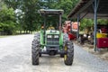 An outdoor green John Deere tractor at a farm with four black wheels
