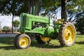 An outdoor green John Deere tractor at a small farm