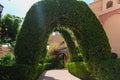 Outdoor Green secret garden with arched entry and gate. Tiled park path in a tunnel under an arch entwined with tropical