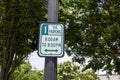 An outdoor green and white one hour parking sign