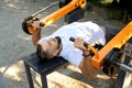 Outdoor gym. Handsome bearded man doing bench press. Outdoor training Royalty Free Stock Photo