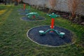 Outdoor gym in the yard with a stone sandstone wall and a flexible circle-shaped rubber floor. sports ground with fitness equipmen