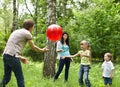 Outdoor happy family plaing ball .