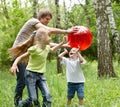 Outdoor happy family plaing ball .